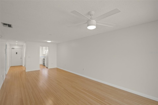 3987 Maceachen Blvd Unit 133, Sarasota, FL 34233 - unfurnished living room featuring visible vents, light wood-style floors, baseboards, a textured ceiling, and a ceiling fan