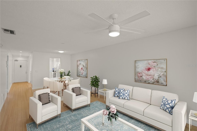 3987 Maceachen Blvd Unit 133, Sarasota, FL 34233 - living area with visible vents, baseboards, a textured ceiling, a ceiling fan, and light wood finished floors
