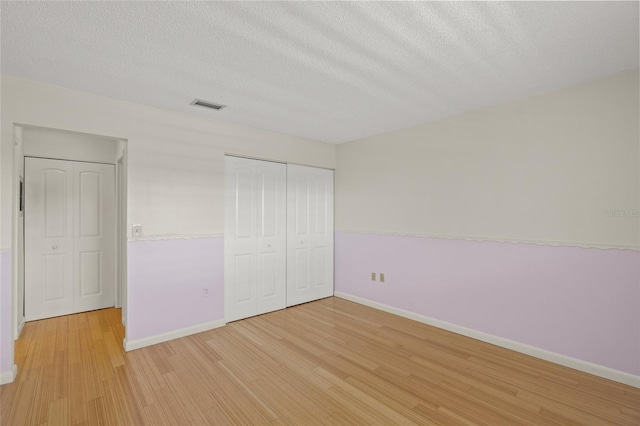 3987 Maceachen Blvd Unit 133, Sarasota, FL 34233 - unfurnished bedroom with light wood-style floors, baseboards, a textured ceiling, and visible vents
