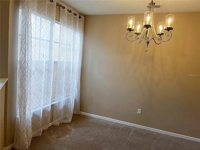 spare room with carpet floors and an inviting chandelier