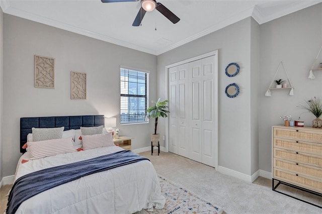 bedroom featuring ornamental molding, ceiling fan, a closet, and light carpet