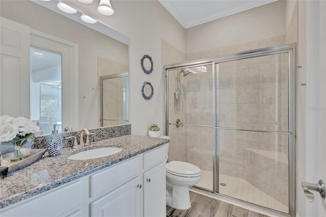 bathroom with toilet, an enclosed shower, wood-type flooring, and vanity