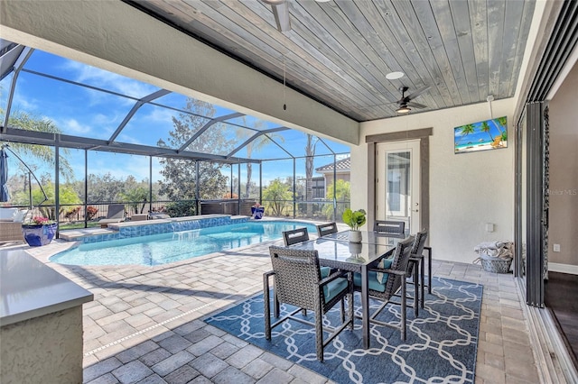 view of swimming pool with a patio area, ceiling fan, and a lanai