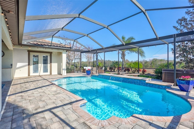 view of pool with a lanai, french doors, and a hot tub