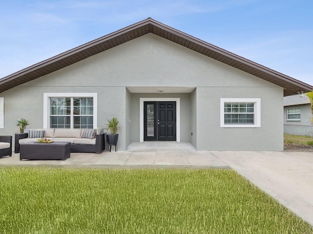 back of house with an outdoor living space and a yard