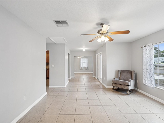 unfurnished room featuring ceiling fan, a textured ceiling, and light tile patterned floors