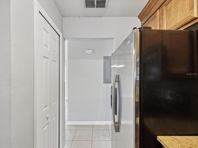 bathroom featuring a textured ceiling and tile patterned flooring