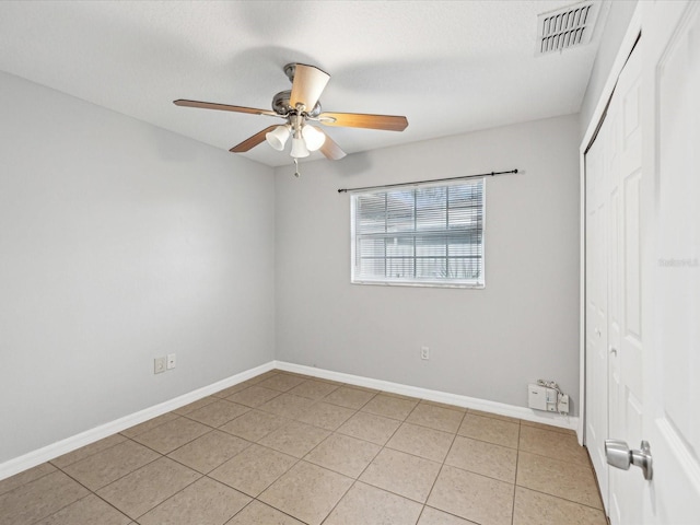 unfurnished bedroom featuring ceiling fan, light tile patterned floors, and a closet