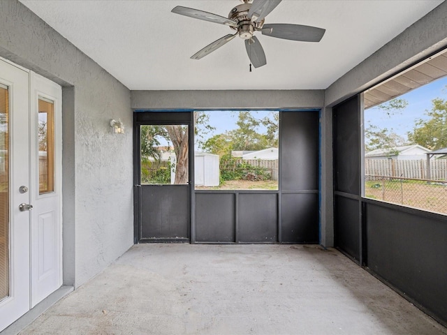 unfurnished sunroom with ceiling fan