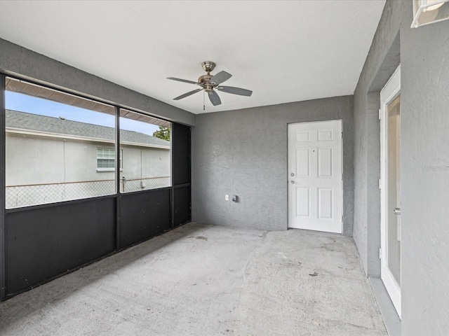 empty room with ceiling fan and concrete floors