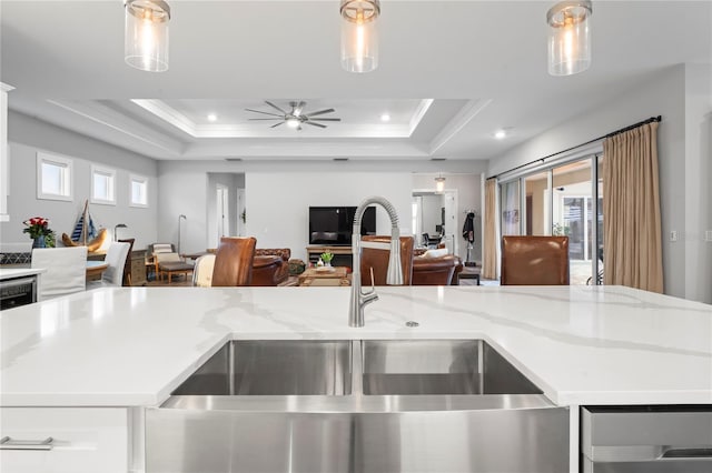 kitchen with crown molding, hanging light fixtures, a tray ceiling, and a wealth of natural light