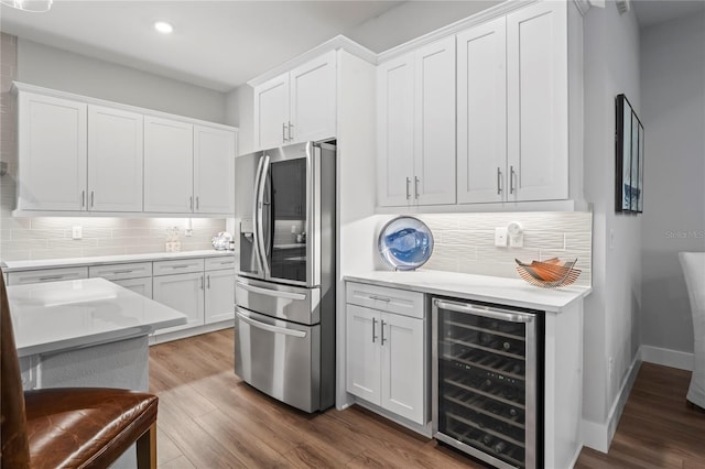 kitchen featuring wood-type flooring, white cabinets, beverage cooler, decorative backsplash, and stainless steel refrigerator with ice dispenser