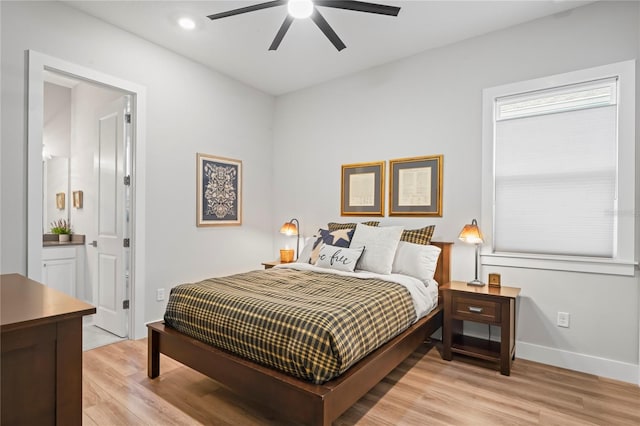 bedroom with connected bathroom, light hardwood / wood-style floors, and ceiling fan