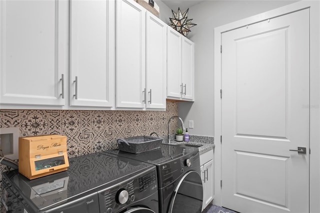 laundry room with sink, washer and clothes dryer, and cabinets