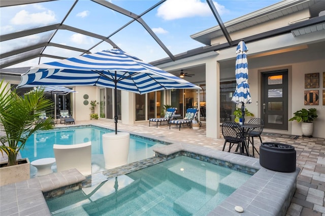 view of pool featuring a patio, an in ground hot tub, ceiling fan, and glass enclosure