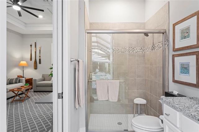 bathroom featuring vanity, ceiling fan, a shower with shower door, and toilet