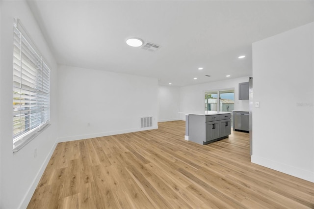 unfurnished living room featuring a healthy amount of sunlight and light wood-type flooring