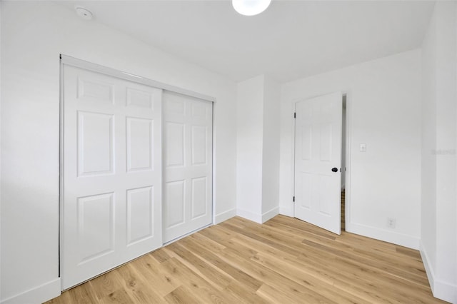 unfurnished bedroom featuring light hardwood / wood-style floors and a closet