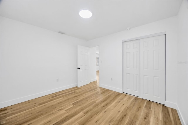 unfurnished bedroom featuring a closet and light hardwood / wood-style floors