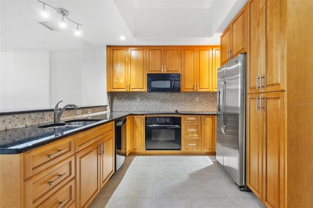 kitchen featuring sink, backsplash, kitchen peninsula, dark stone counters, and black appliances