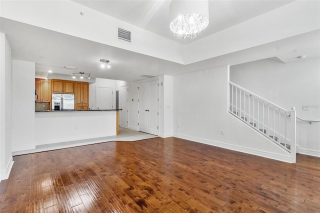 unfurnished living room featuring light hardwood / wood-style flooring and an inviting chandelier