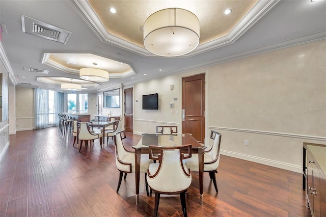 dining space featuring a tray ceiling, dark hardwood / wood-style flooring, and ornamental molding