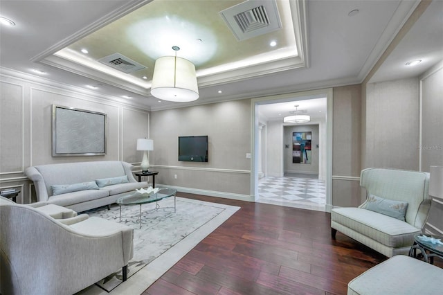 living room with dark hardwood / wood-style flooring, a raised ceiling, and crown molding