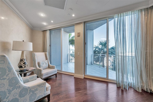 living area featuring ornamental molding, dark hardwood / wood-style flooring, and a healthy amount of sunlight