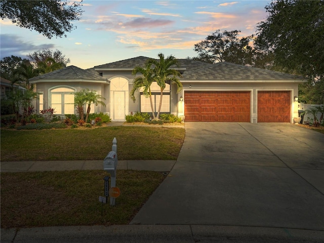 view of front facade with a garage and a yard