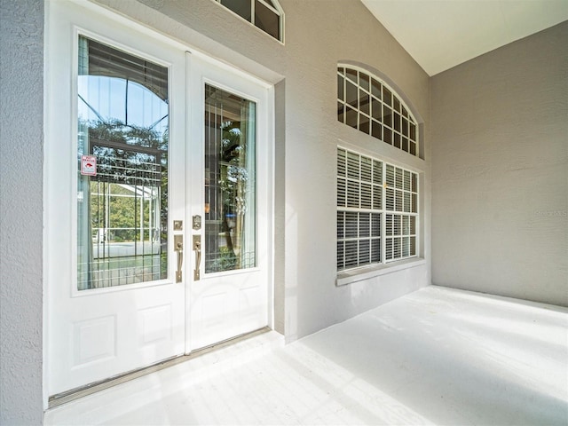 view of exterior entry with a patio area and french doors