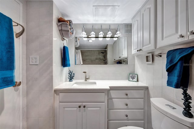 bathroom featuring vanity, decorative backsplash, tile walls, toilet, and walk in shower