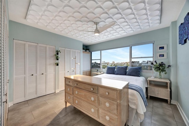 tiled bedroom featuring two closets