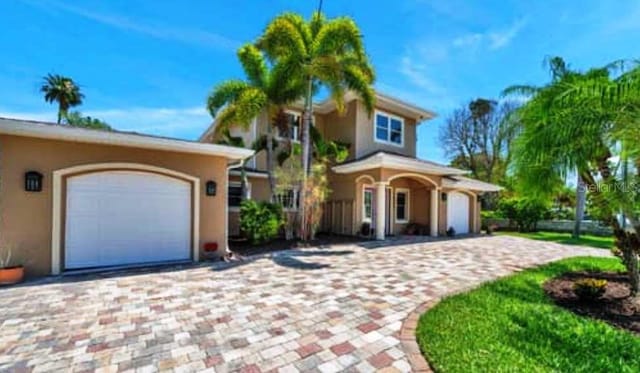 view of front of home with stucco siding and decorative driveway