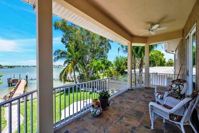 view of patio featuring a balcony, ceiling fan, and a water view