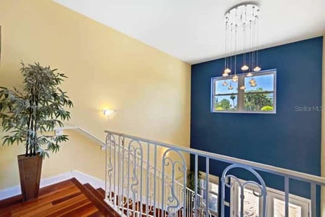 hallway with a chandelier and dark hardwood / wood-style floors