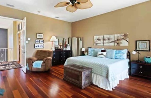 bedroom with ceiling fan and dark hardwood / wood-style flooring