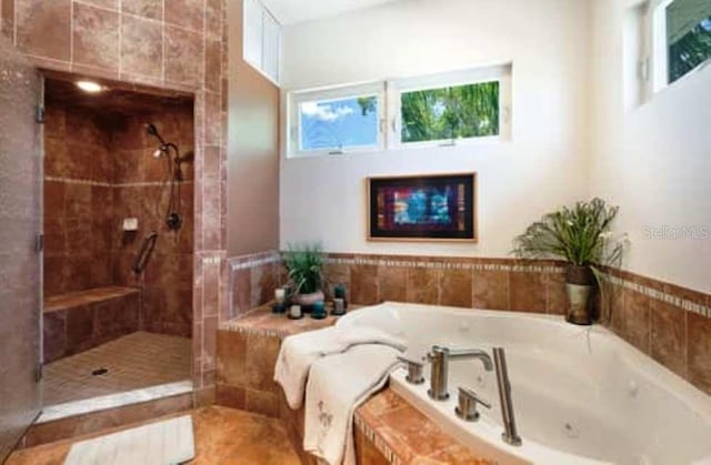 bathroom with separate shower and tub and tile patterned floors