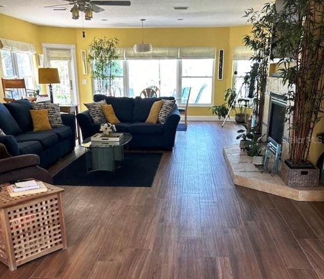 living room featuring ceiling fan and dark hardwood / wood-style flooring