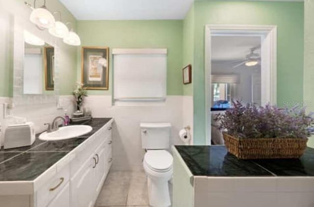 bathroom featuring toilet, vanity, tile patterned flooring, and ceiling fan