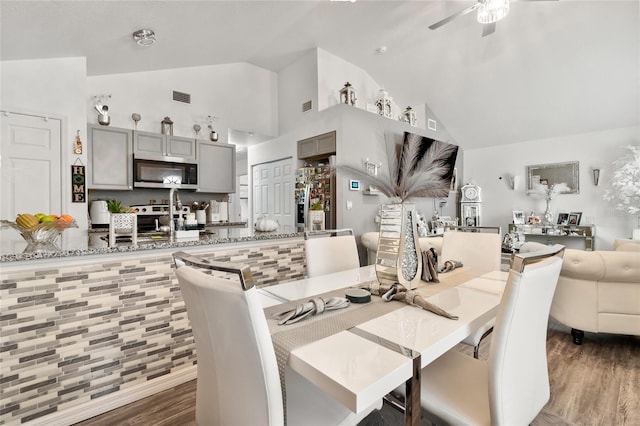 dining area featuring ceiling fan, vaulted ceiling, and hardwood / wood-style floors