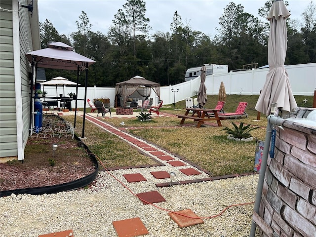 view of yard featuring a gazebo, a patio area, and a fire pit