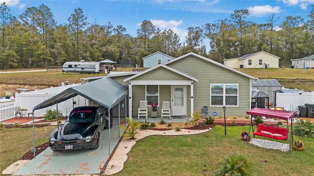 view of front of property with a porch, a carport, and a front lawn