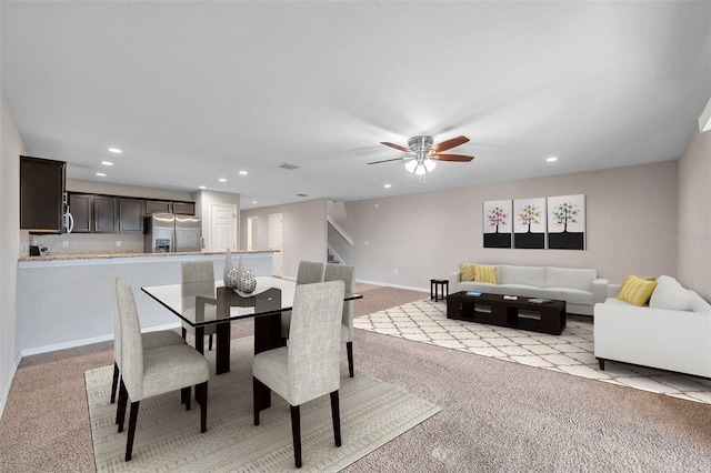 carpeted dining area with ceiling fan