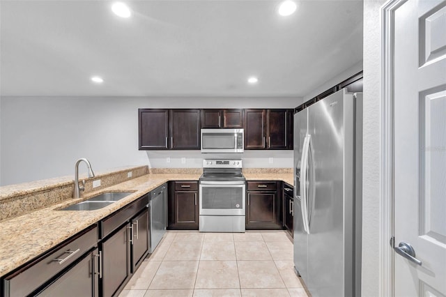 kitchen featuring light tile patterned flooring, sink, stainless steel appliances, light stone countertops, and dark brown cabinets