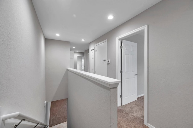 hallway featuring light colored carpet