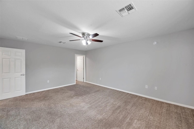 carpeted spare room featuring ceiling fan