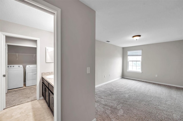 interior space featuring washing machine and clothes dryer and light carpet