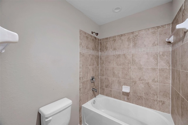 bathroom with toilet and tiled shower / bath combo