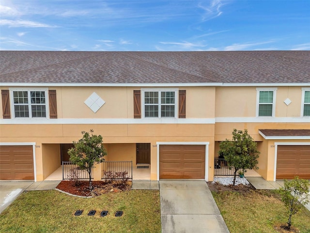 view of property featuring a garage, a front lawn, and a porch