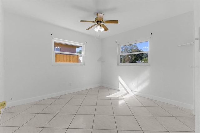 tiled empty room with plenty of natural light and ceiling fan